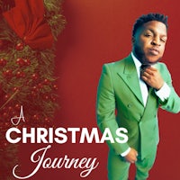 a man in a green suit standing in front of a christmas tree